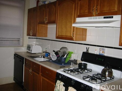 A kitchen with a white stove top and wooden cabinets.