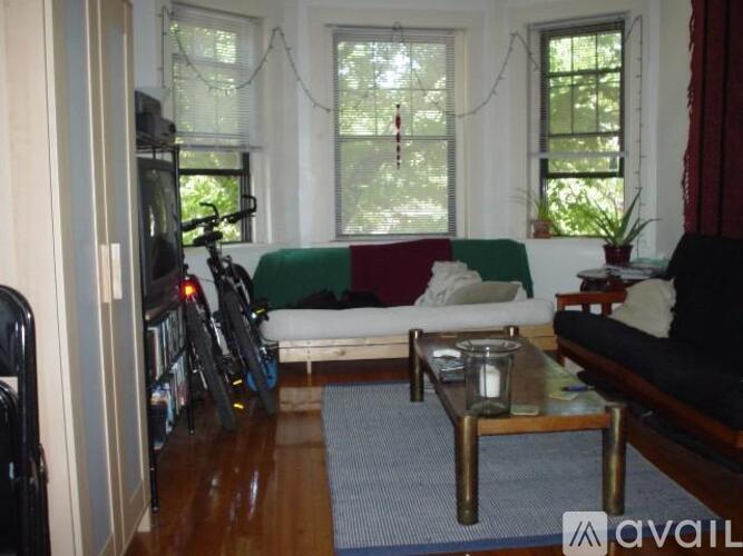 A living room with a couch, a chair, a coffee table, and a bicycle.