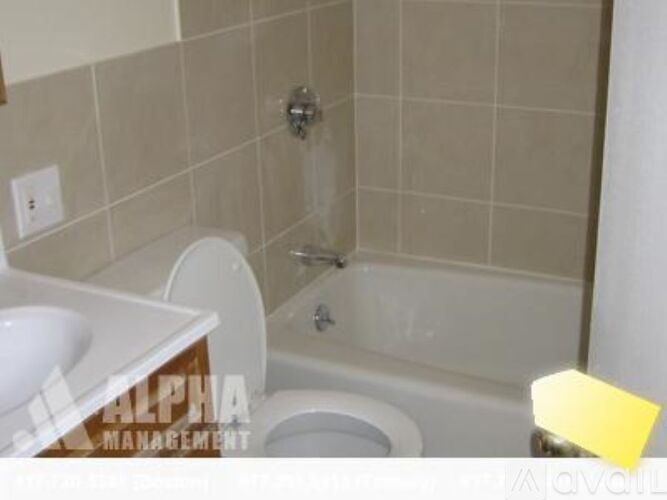 A bathroom with a toilet, sink, and bathtub.