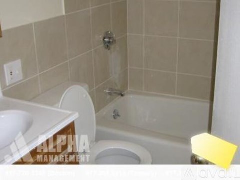 A bathroom with a toilet, sink, and bathtub.