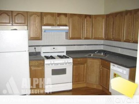 A kitchen with wooden cabinets and a white fridge.