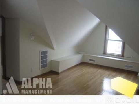 A room with a window and a skylight is available for rent.