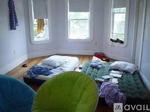 A room with a bed, a chair and a window.