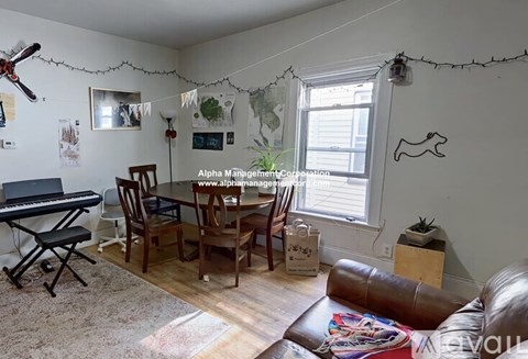 A living room with a piano, chairs, and a dining table.