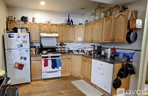 A kitchen with wooden cabinets and a white fridge.