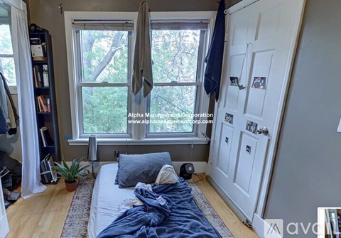 A bedroom with a bed, a window, and a door.