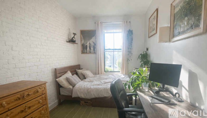 A bedroom with a bed, desk, and chair.