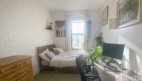 A bedroom with a bed, desk, and chair.