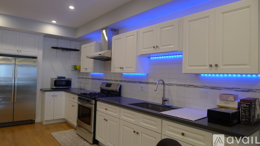 A kitchen with white cabinets and a black countertop.