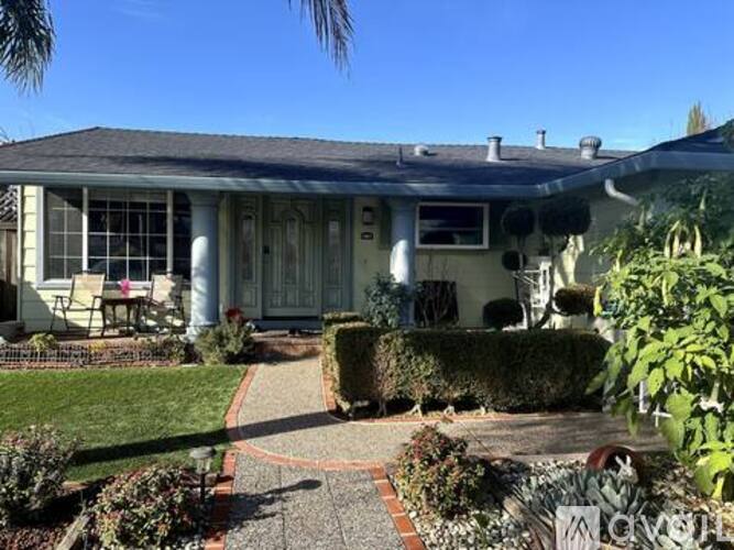 A house with a front yard and a pathway leading to the front door.