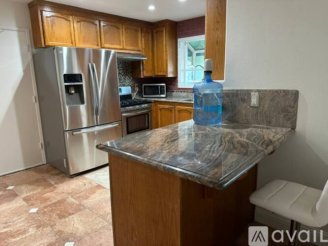 A kitchen with a granite countertop and a refrigerator.