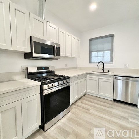 A kitchen with white cabinets and stainless steel appliances.