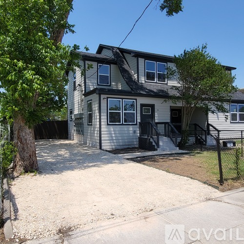 A two-story house with a grey exterior and a black fence.