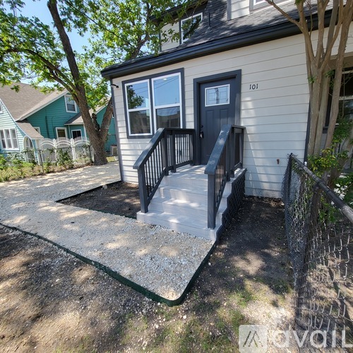 A house numbered 101 has a small deck with a black railing.