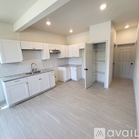A kitchen with white cabinets and a sink.