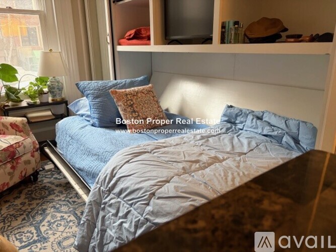 A bedroom with a large bed and a fireplace.
