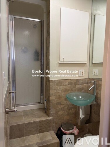 A bathroom with a glass table and toilet paper on the steps.