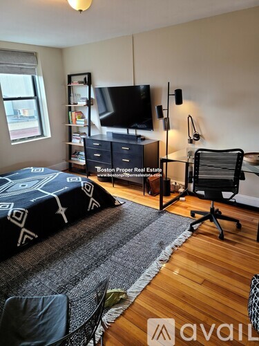 A bedroom with a bed, desk, and chair.