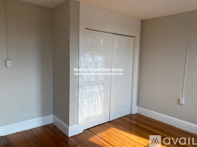 A room with wooden floors and a white door.