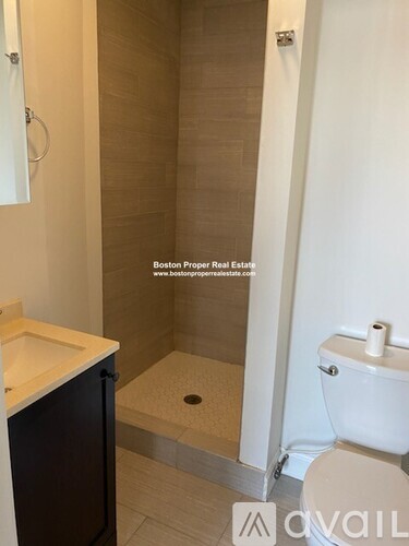 A bathroom with a toilet, sink, and shower.