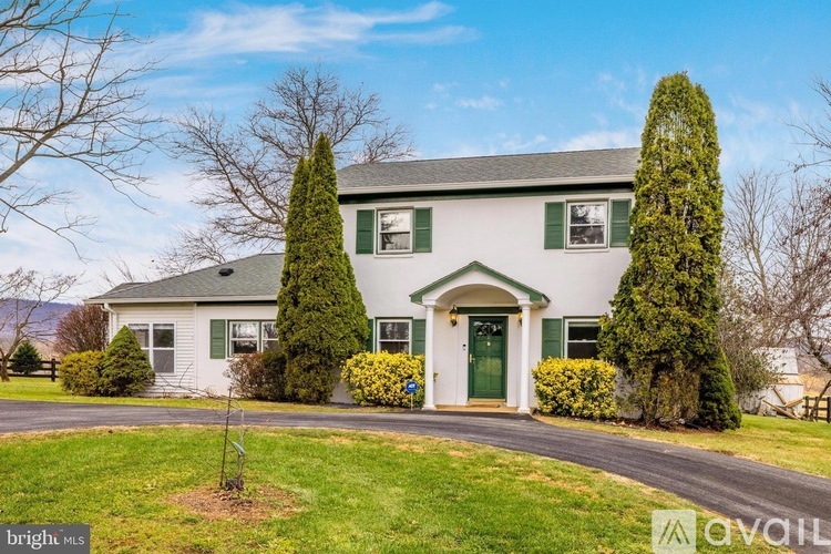 A house with a green door and a driveway in front.