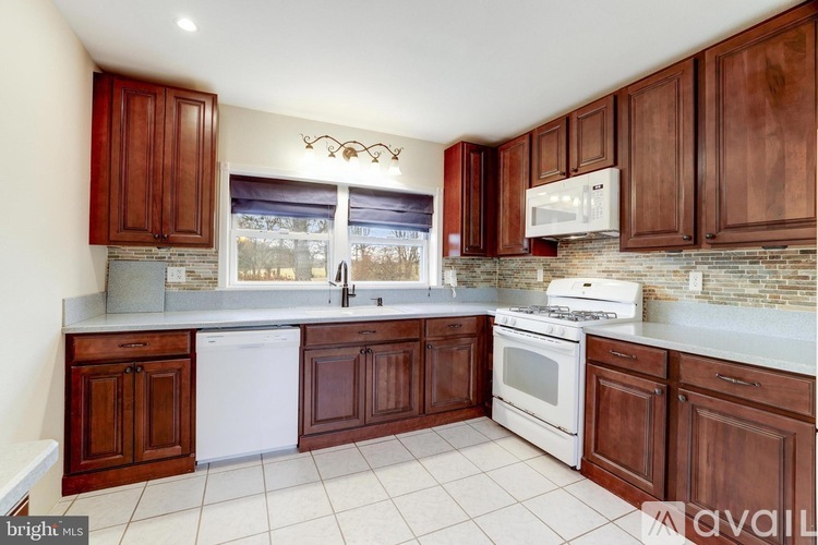 A kitchen with brown cabinets and white appliances.