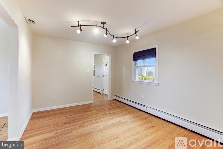 A room with wooden floors and a window with a view of trees outside.