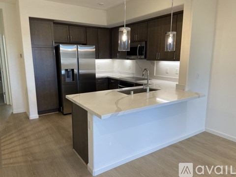 A modern kitchen with dark brown cabinets and a white island.