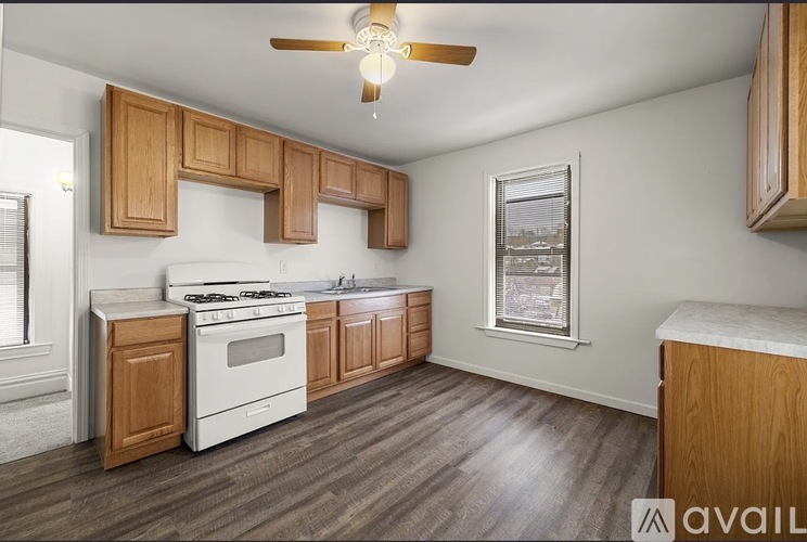 A kitchen with wooden cabinets and a white stove top oven.