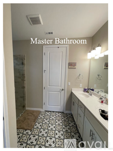 A bathroom with a white door and a mirror above the sink.