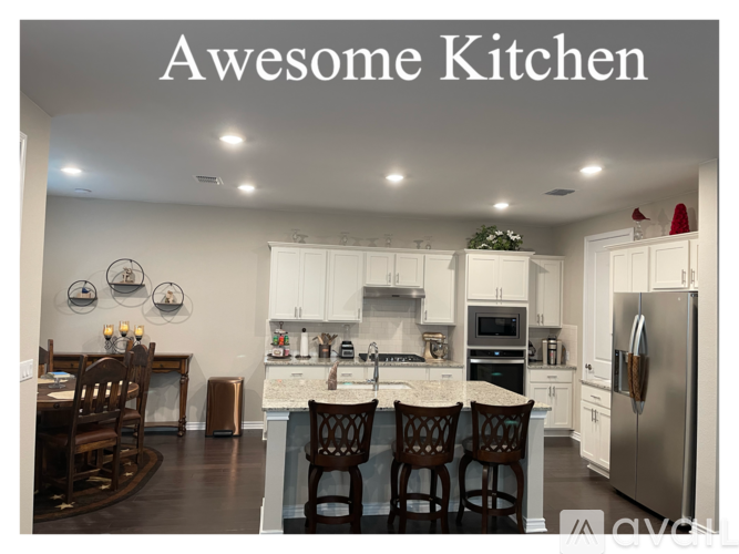 A kitchen with white cabinets and a large island.