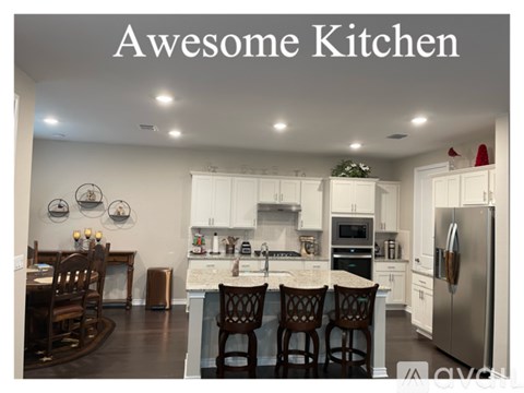 A kitchen with white cabinets and a large island.