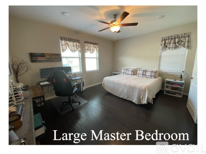 A large bedroom with a bed, desk, and chair.