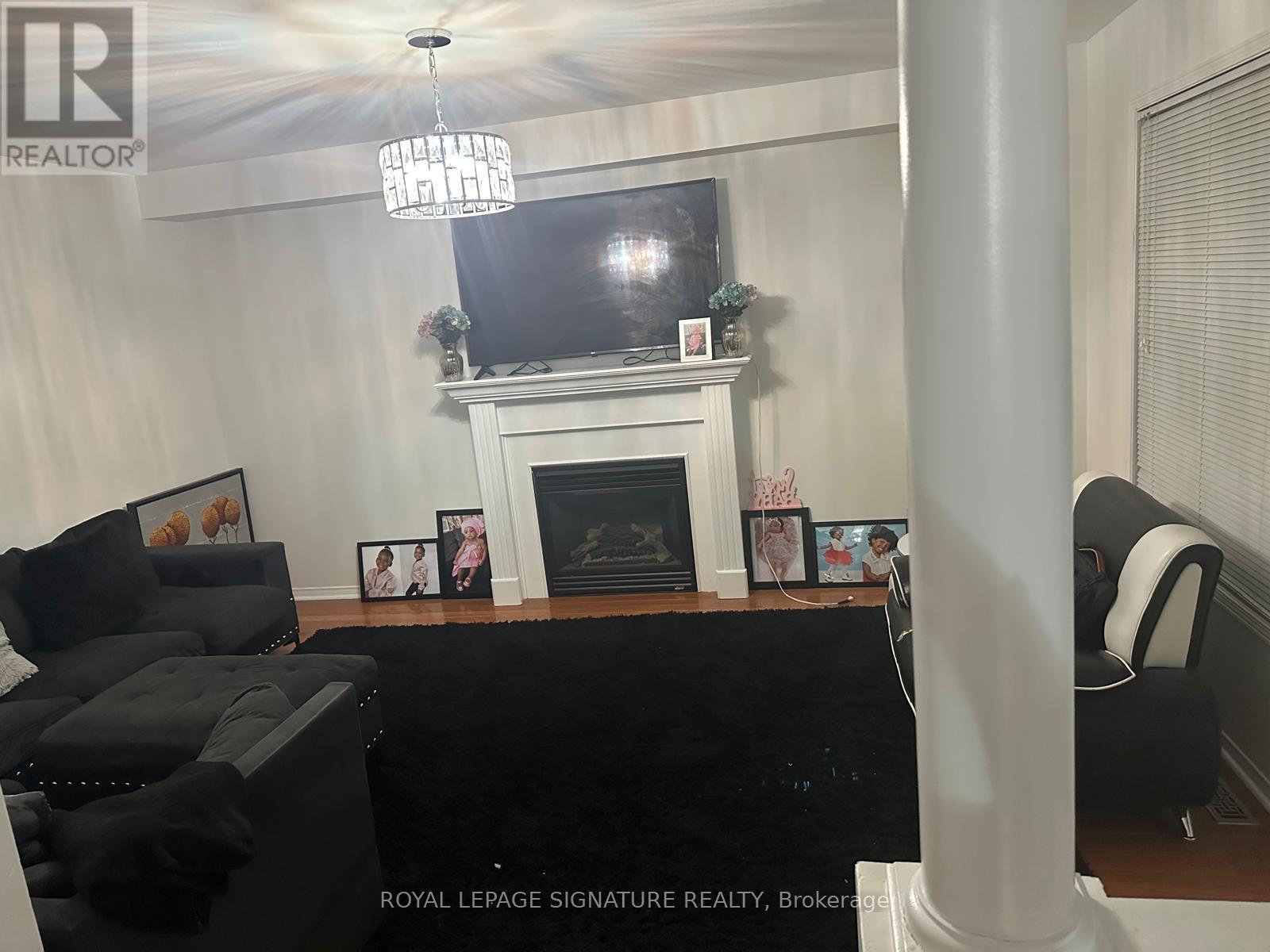 A living room with a fireplace and a flat screen TV mounted above it.