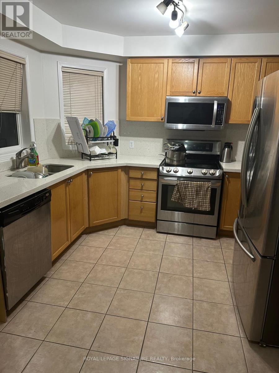 A kitchen with a refrigerator, oven, and microwave.