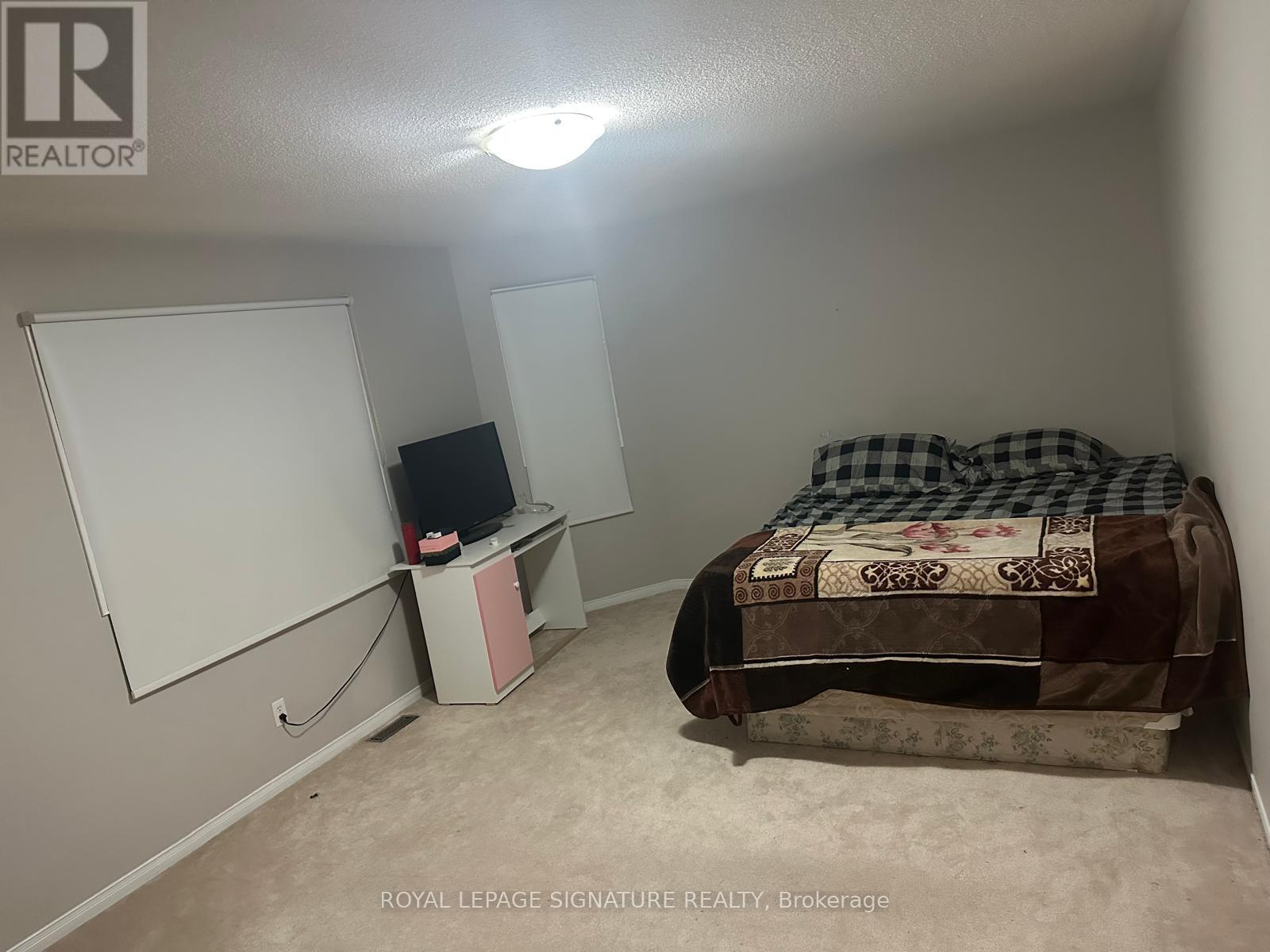 A bedroom with a bed, dresser, and a whiteboard.