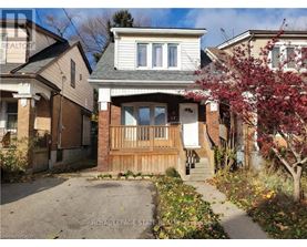A house with a front yard and a tree with red leaves.