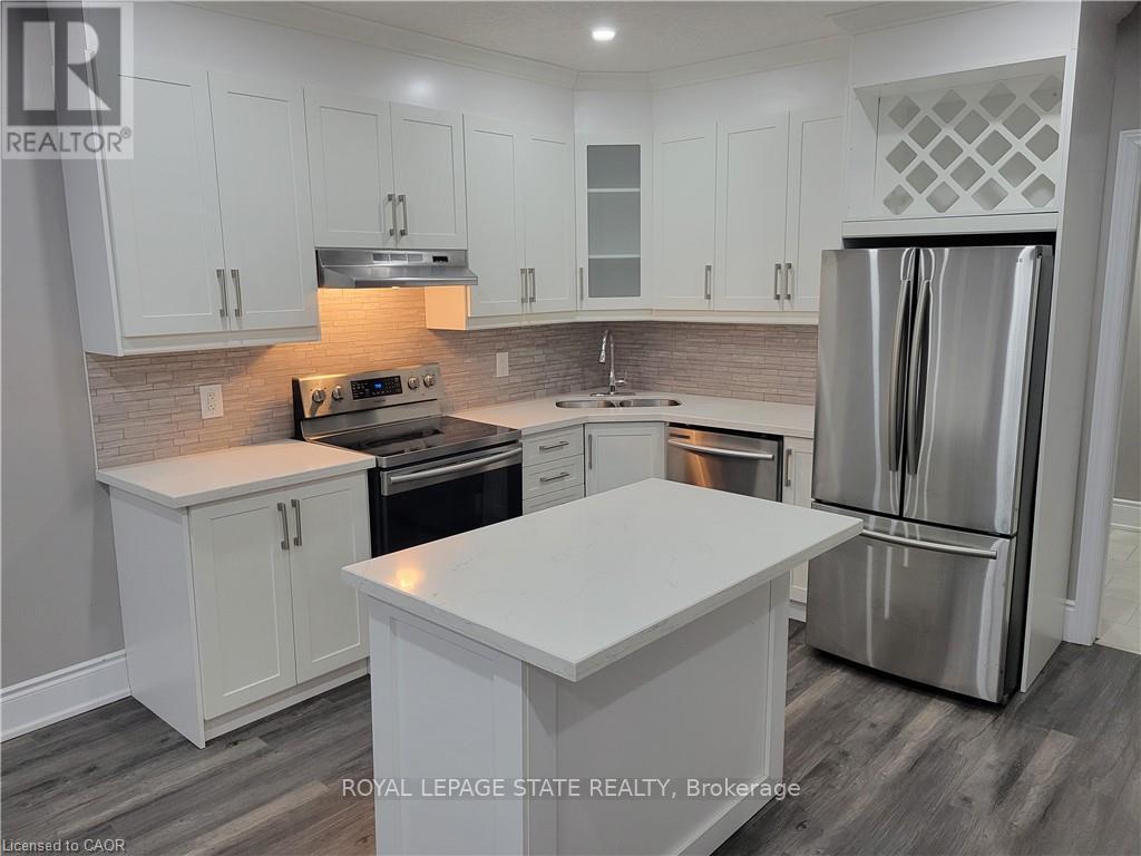 A modern kitchen with white cabinets and stainless steel appliances.