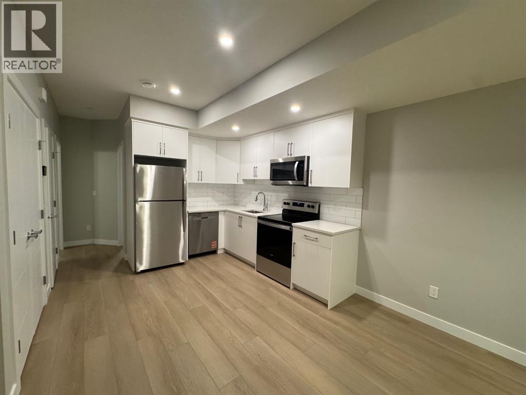 A kitchen with a refrigerator, dishwasher, and oven.