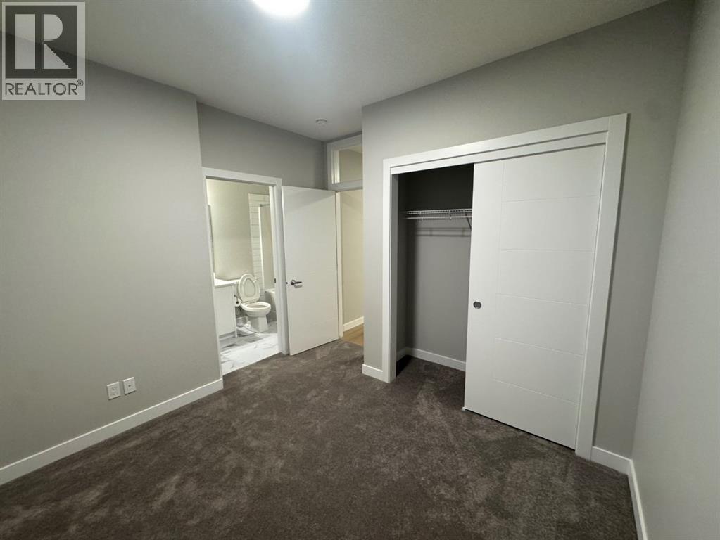 A bedroom with a carpeted floor and a white door.