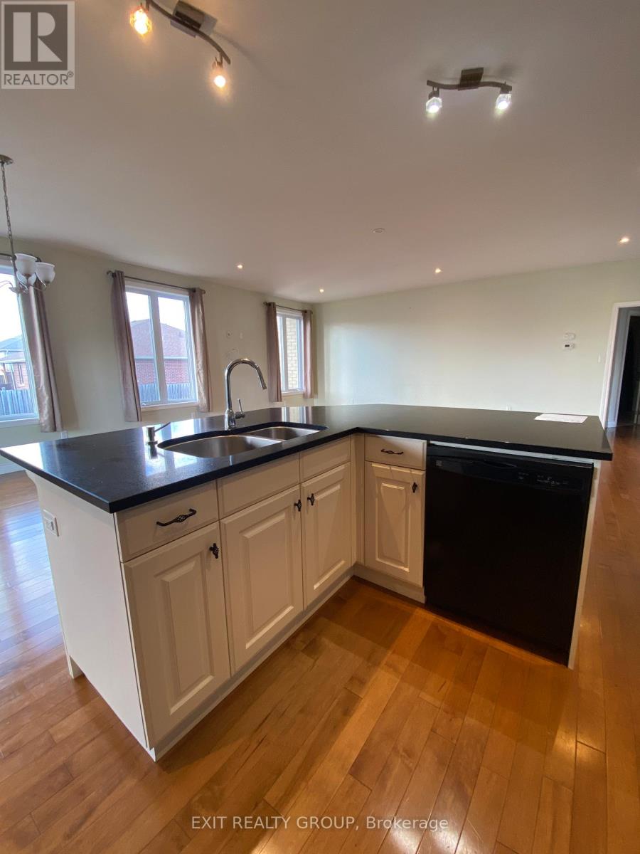 A kitchen with white cabinets and black countertops.
