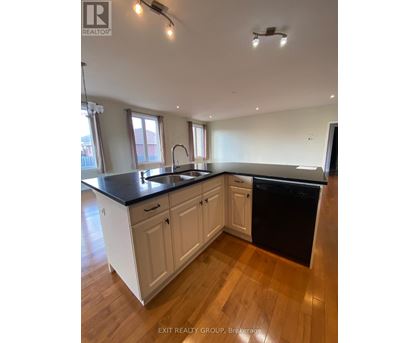 A kitchen with white cabinets and black countertops.