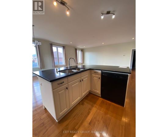 A kitchen with white cabinets and black countertops.