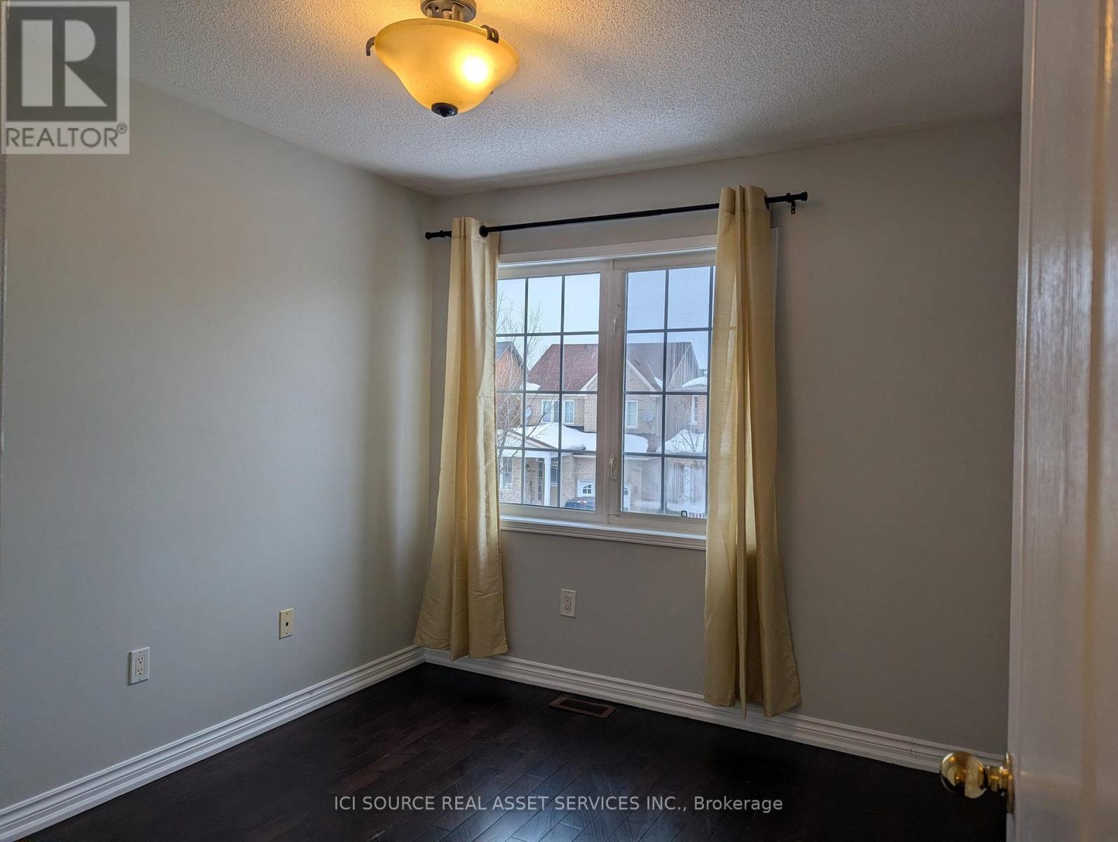 A room with a window and curtains.