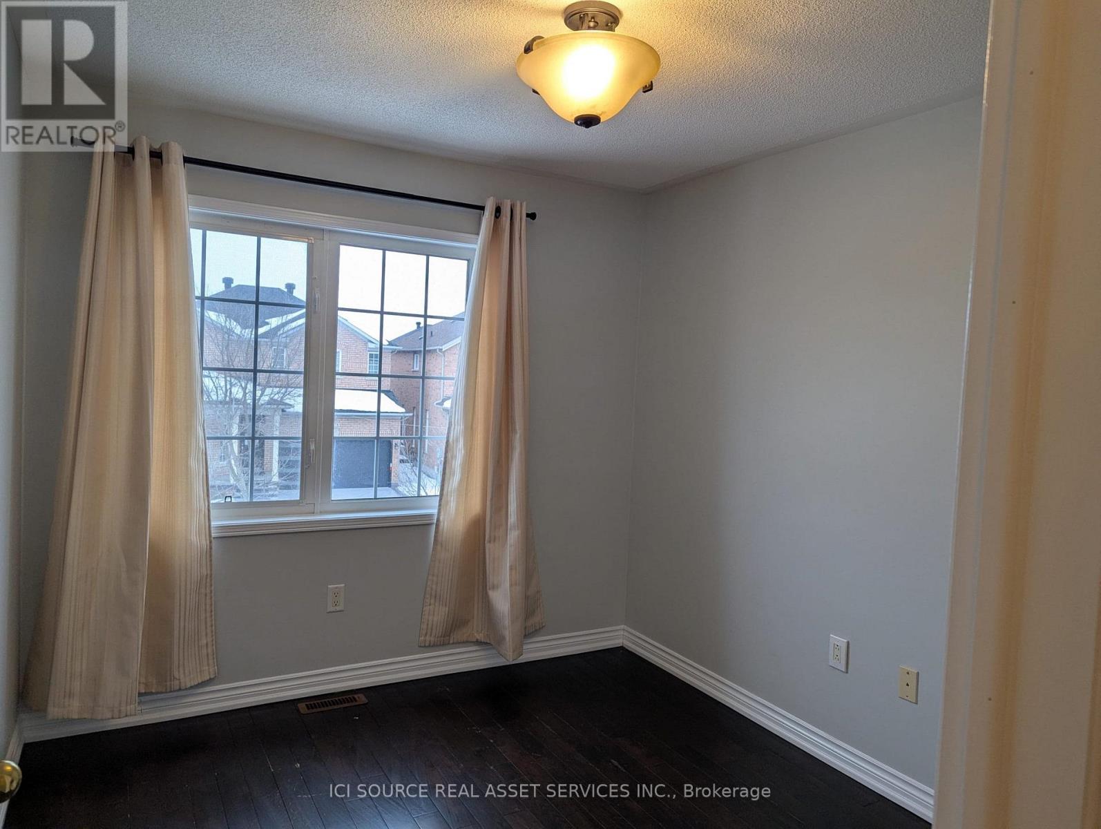 A room with a window and curtains.