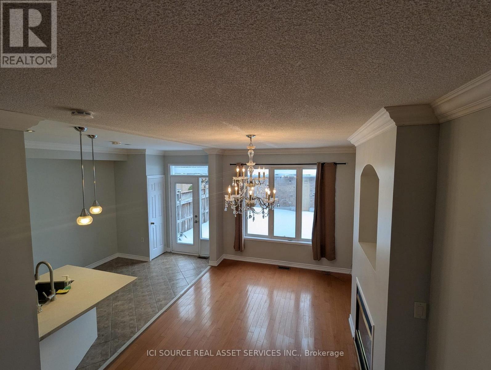 A well-lit room with a chandelier and a kitchen counter.