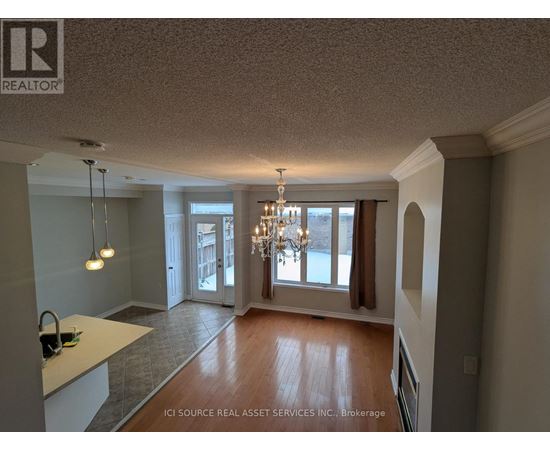 A well-lit room with a chandelier and a kitchen counter.