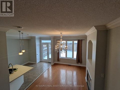 A well-lit room with a chandelier and a kitchen counter.