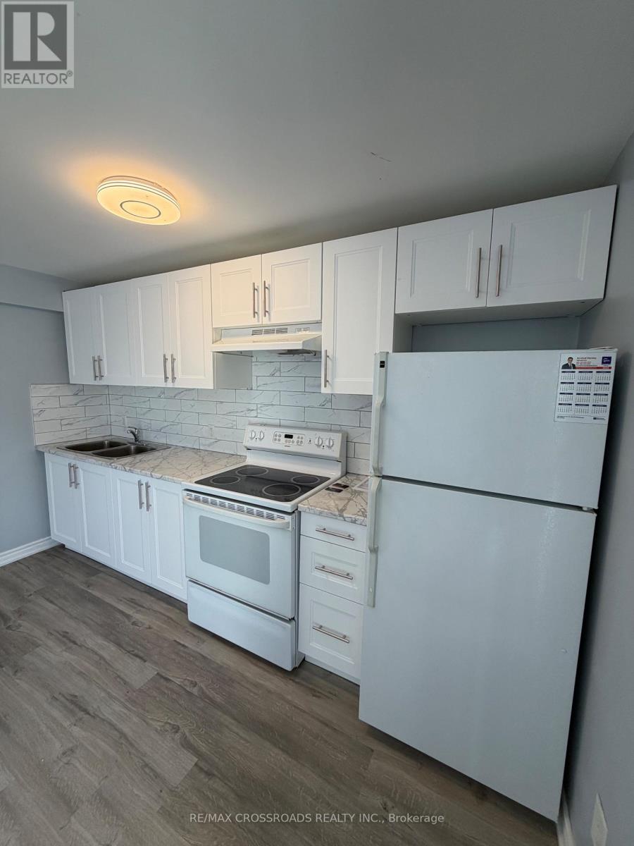 A spacious kitchen with white appliances and wooden cabinets.