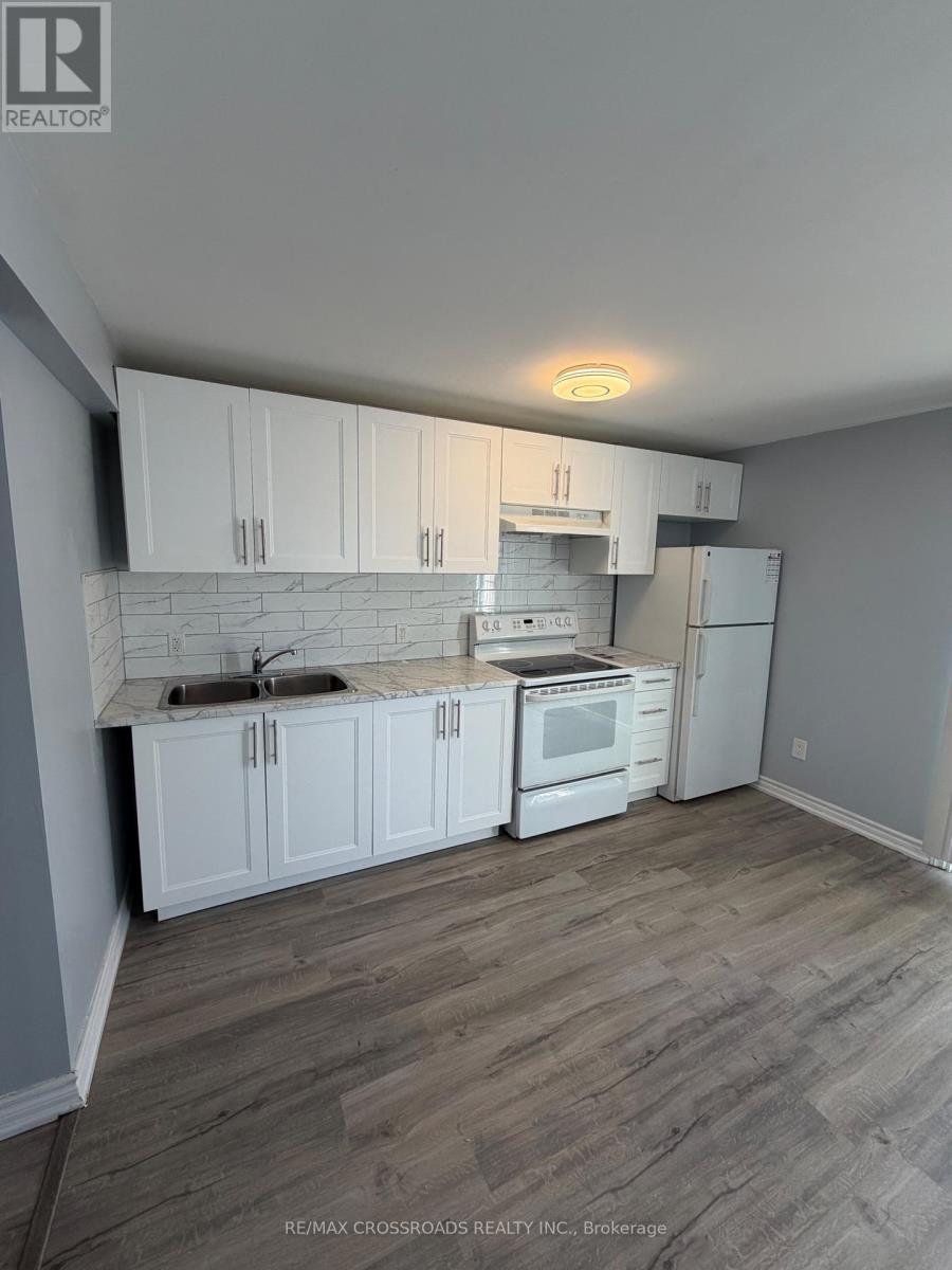 A kitchen with white appliances and wooden cabinets is shown in a real estate listing.